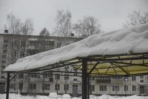 Snow on roof of veranda. Snow on roof of steel structure. Snowy weather. photo