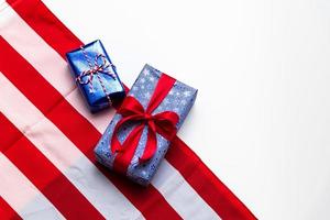 4 de julio tarjeta del feliz día de la independencia estadounidense con cajas de regalo en colores nacionales bandera estadounidense sobre fondo blanco, endecha plana, vista superior, espacio de copia, pancarta foto