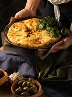 A vertical shot of a chef serving a gourmet Georgian dish photo
