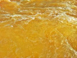 Defocus blurred transparent orange colored clear calm water surface texture with splash, bubble. Shining orange water ripple background. Surface of water in swimming pool. Orange bubble water, splash. photo