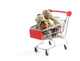 Heap of quail eggs in shopping cart isolated on white photo