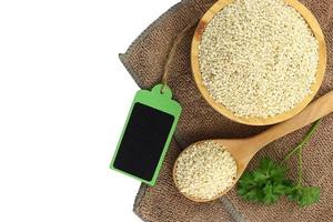 Top view - White sesame seeds in bowl  and blank wooden tag photo