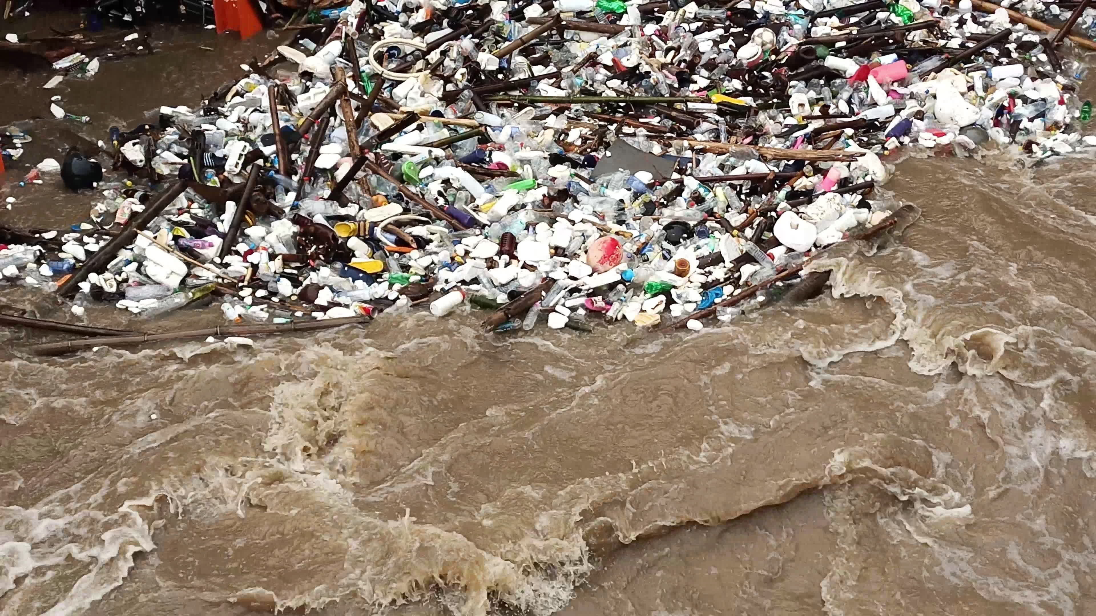 Aerial view of turbid brown forest water released by concrete dam