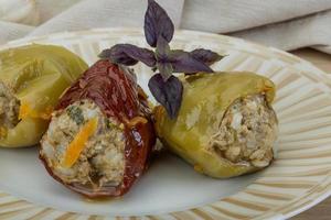 Stuffed peppers on the plate and wooden background photo