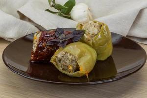 Stuffed peppers on the plate and wooden background photo