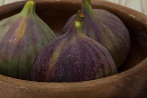 Figs in a bowl on wooden background photo