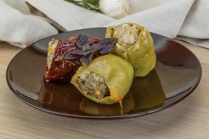 Stuffed peppers on the plate and wooden background photo