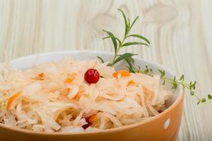 Sauerkraut in a bowl on wooden background photo
