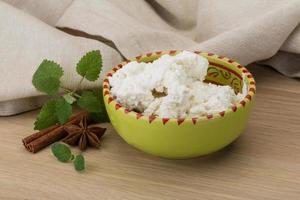 Ricotta cheese in a bowl on wooden background photo