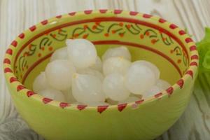 Marinated onion in a bowl on wooden background photo