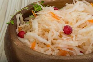 Sauerkraut in a bowl on wooden background photo