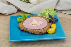 Sausage sandwich on the plate and wooden background photo