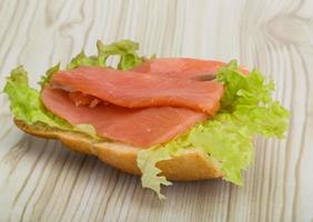 Salmon sandwich on wooden background photo