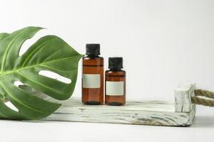 aceite natural para el cabello cbd o suero parado en la bandeja de madera blanca foto