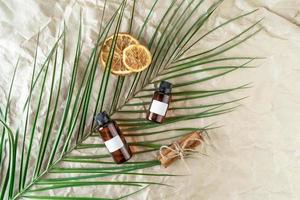 A face serum or essential oil with blank labels on them lying on a beige craft paper background photo