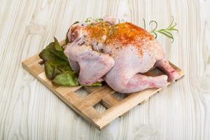 Raw chicken on wooden board and wooden background photo