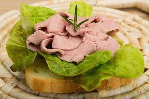 Liver sandwich on wooden background photo