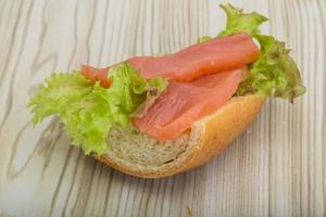 sándwich de salmón sobre fondo de madera foto