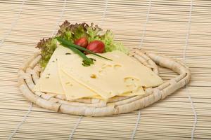 Maasdam cheese on wooden board and wooden background photo