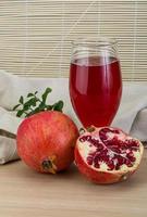 Pomecranet juice on wooden background photo