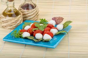 ensalada caprese en el plato y fondo de madera foto