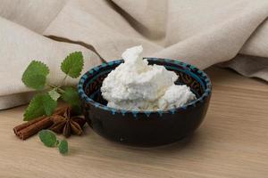 Ricotta cheese in a bowl on wooden background photo