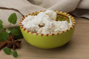 Ricotta cheese in a bowl on wooden background photo