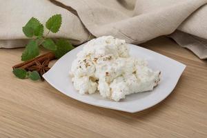 Ricotta cheese on the plate and wooden background photo