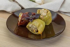 Stuffed peppers on the plate and wooden background photo