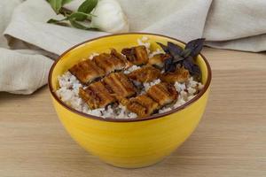 Eel with rice in a bowl on wooden background photo