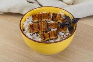 Eel with rice in a bowl on wooden background photo