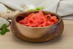 Marinated ginger in a bowl on wooden background photo