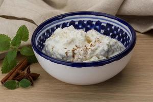 Ricotta cheese in a bowl on wooden background photo