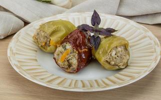 Stuffed peppers on the plate and wooden background photo