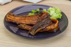 Eel on the plate and wooden background photo