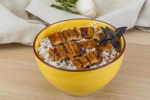 Eel with rice in a bowl on wooden background photo