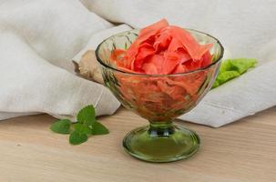 Marinated ginger in a bowl on wooden background photo