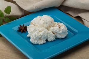 Ricotta cheese on the plate and wooden background photo