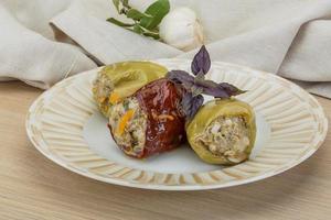 Stuffed peppers on the plate and wooden background photo