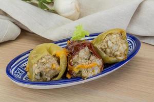 Stuffed peppers in a bowl on wooden background photo