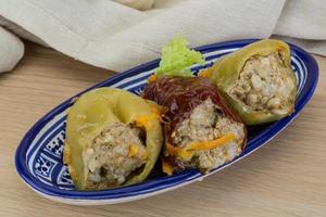 Stuffed peppers in a bowl on wooden background photo