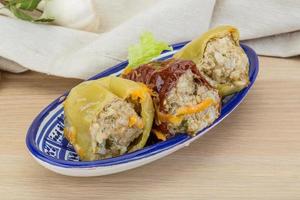 Stuffed peppers in a bowl on wooden background photo