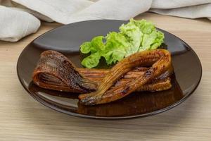 Eel on the plate and wooden background photo