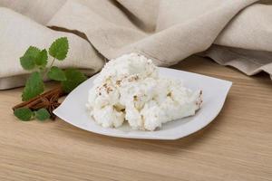 Ricotta cheese on the plate and wooden background photo