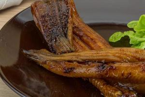 Eel on the plate and wooden background photo