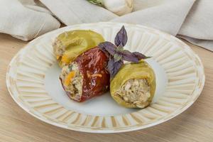 Stuffed peppers on the plate and wooden background photo