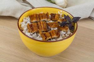 Eel with rice in a bowl on wooden background photo