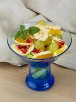 Fruit salad in a bowl on wooden background photo