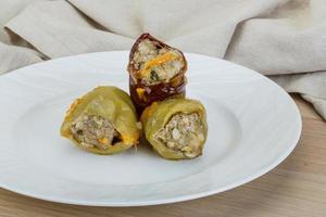 Stuffed peppers on the plate and wooden background photo