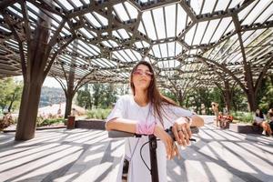 Young beautiful woman and an electric scooter, ecological transport photo